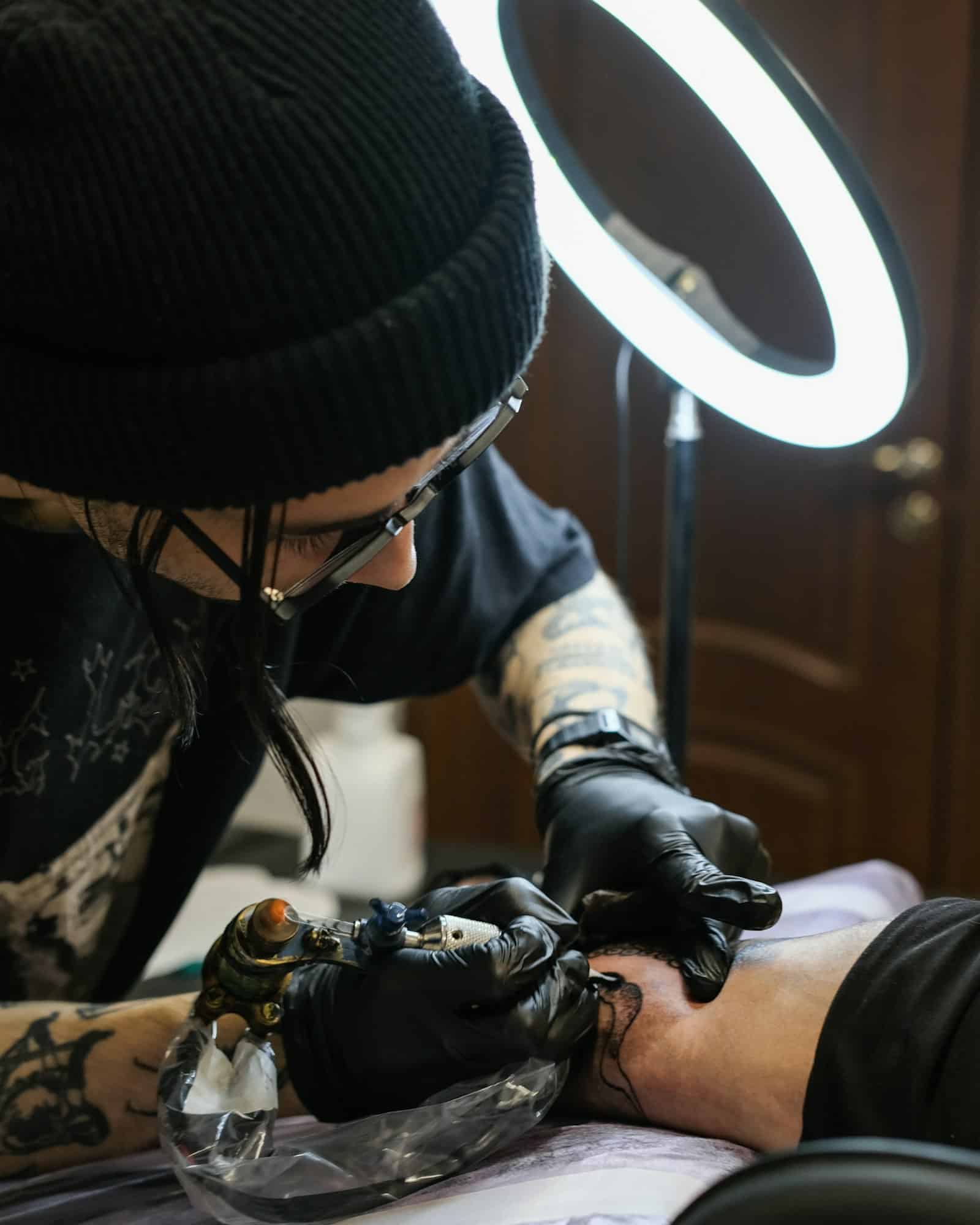 Professional tattoo artist stuffs a tattoo on the man's hand. Small business.